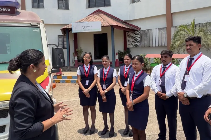 A trainer briefing IESP students in uniform outside the Khalapur centre building