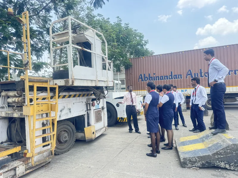 Students in uniform at a main deck loader during ground equipment training
